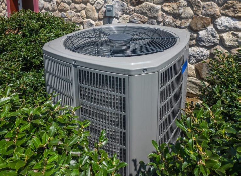 Air conditioning and heating unit for a residential house hidden by holly