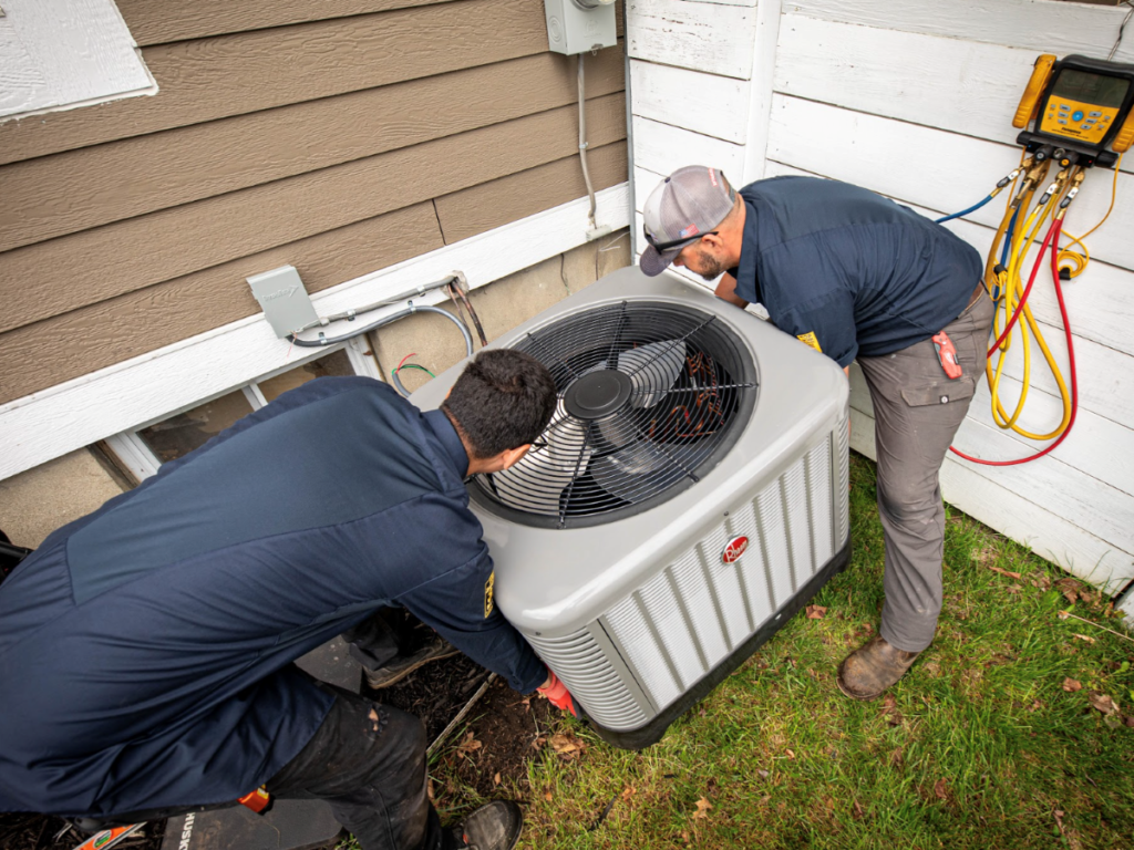 ac refrigerant Rolls Mechanical technicians working with air conditioner unit outside a house