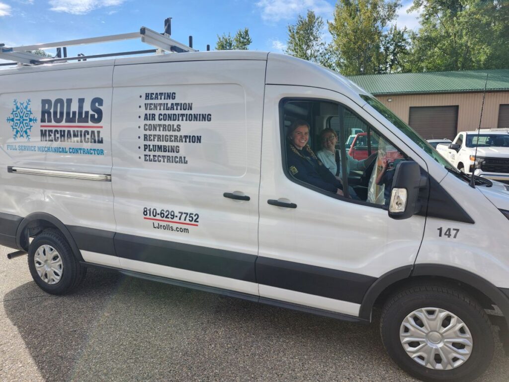 furnace replacement cost Rolls Mechanical white van with two young women driving