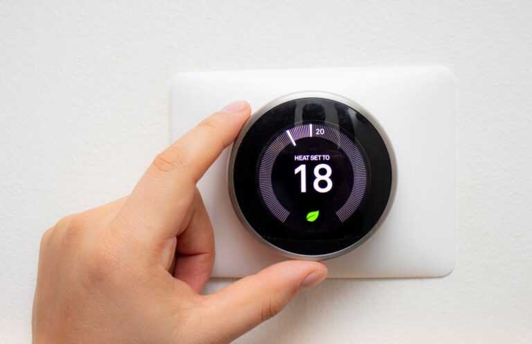 hand adjusting temperature smart thermostat installation