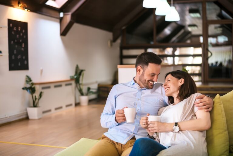 Couple enjoying coffee on sofa.