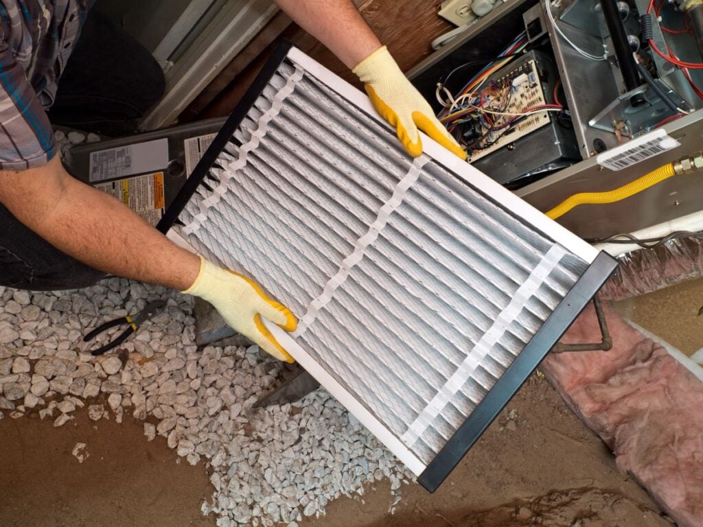 emergency furnace repair worker holding clean filter