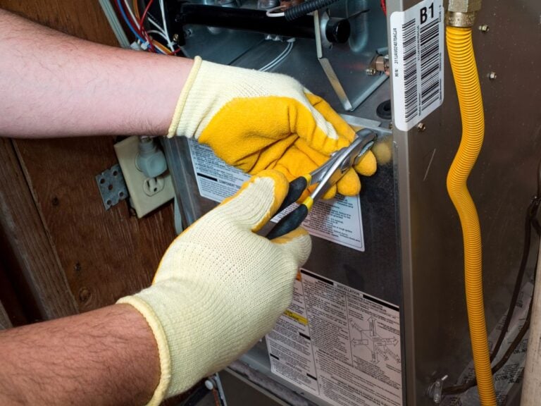 emergency furnace repair worker repairing AC