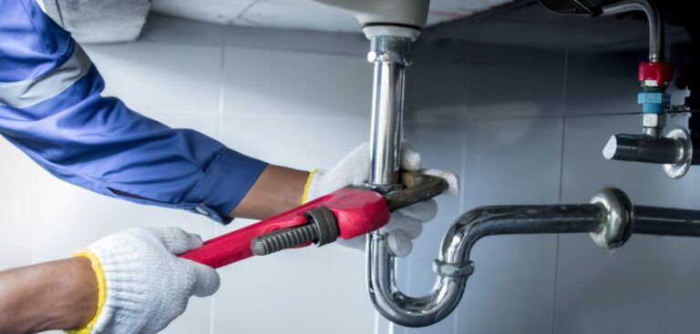 plumbing toledo worker using wrench to adjust pipe
