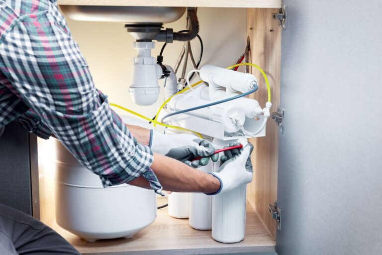 plumbing hartland man installing unit under sink