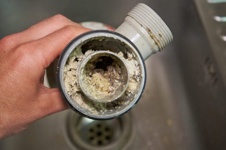 sewer drain cleaning in the hands of a clogged dirty sewer pipe from leftover food