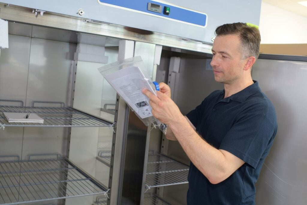 refrigeration maintenance worker doing maintenance on unit