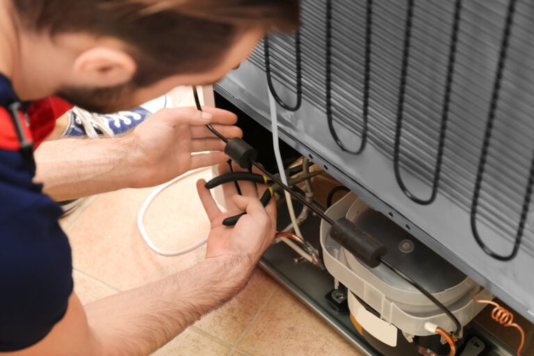 commercial refrigeration equipment Male technician repairing refrigerator indoors
