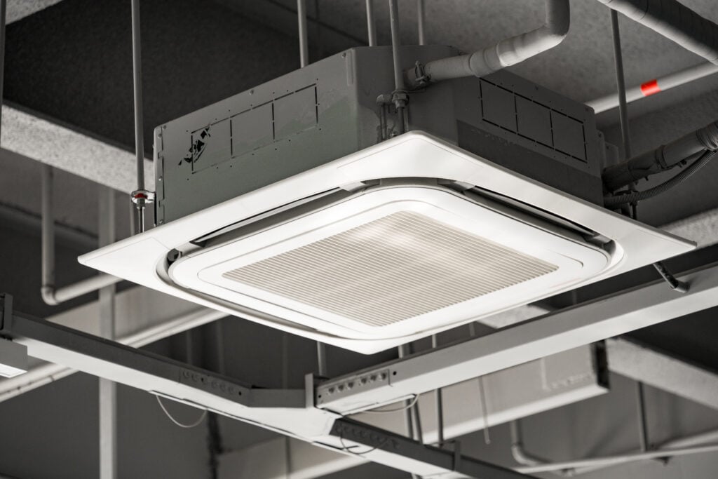 commercial ac unit Ceiling-mounted square cassette air conditioning unit with metal grille and ventilation system