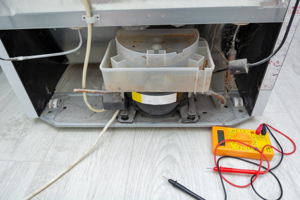 commercial refrigeration equipment Technician Checking Fridge With Digital Multimeter. Repairman contractor repairing fridge and home appliances