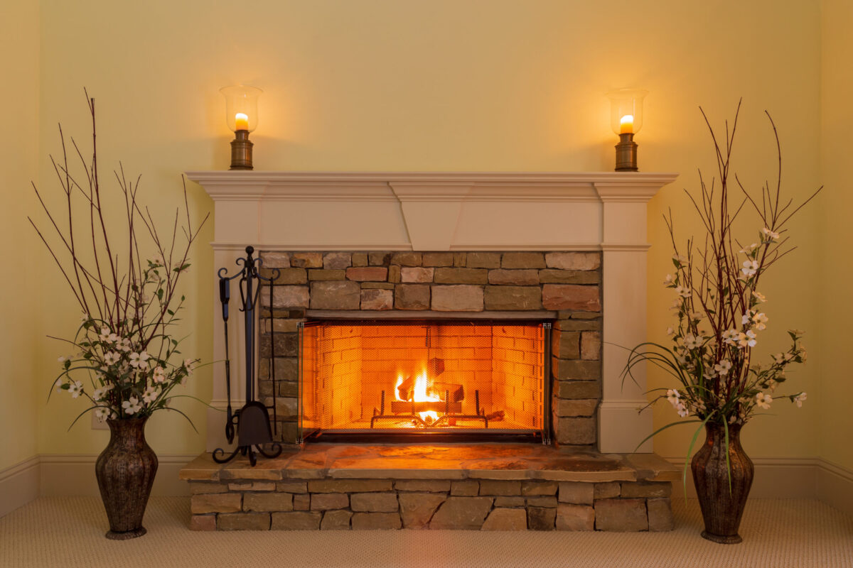 fireplace installation east lansing Cozy fire in a stone fireplace in a residential home with candles and flowers.