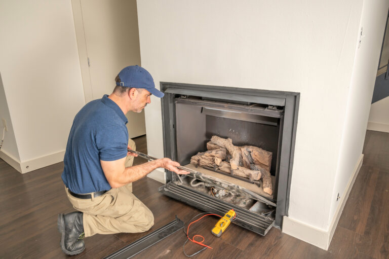 fireplace installation east lansing worker installing Service technician repairing a gas fireplace in a home