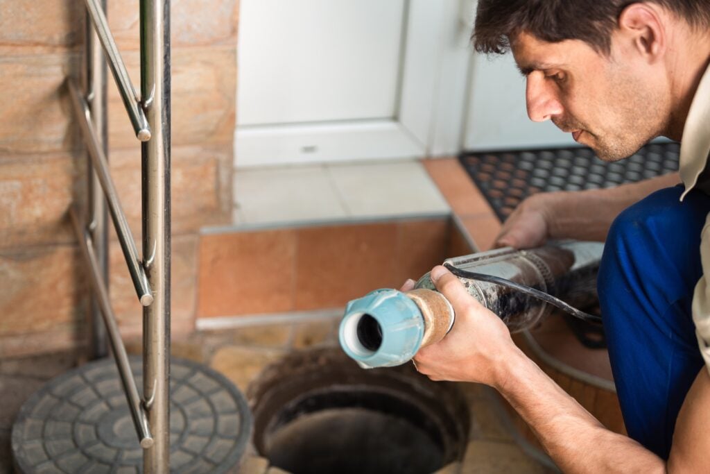 hydro jet drain cleaning Worker performs the installation of pumping equipment. Sewer cleaning