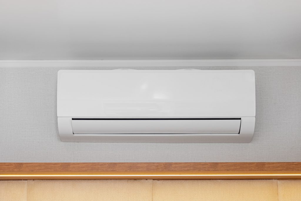 ductless mini split system White Air Conditioner Mini Split Unit Mounted at Wall in Room